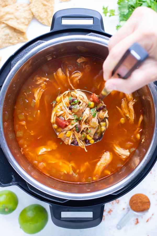 Instant pot chicken tortilla soup is served with a ladle.