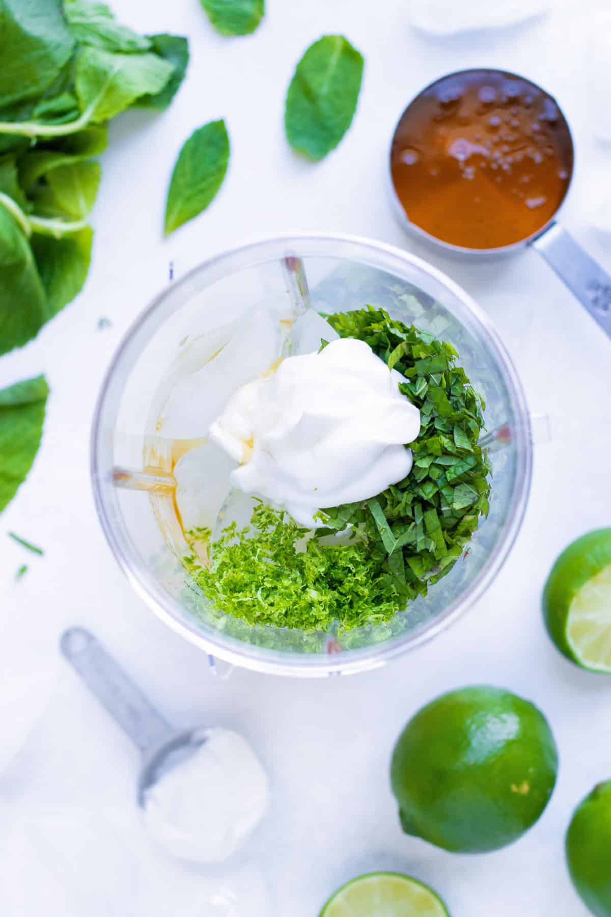 The ingredients to make a mojito are added to a blender.