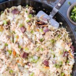 A Reuben in a bowl is being served up with a spatula with Thousand Island dressing.