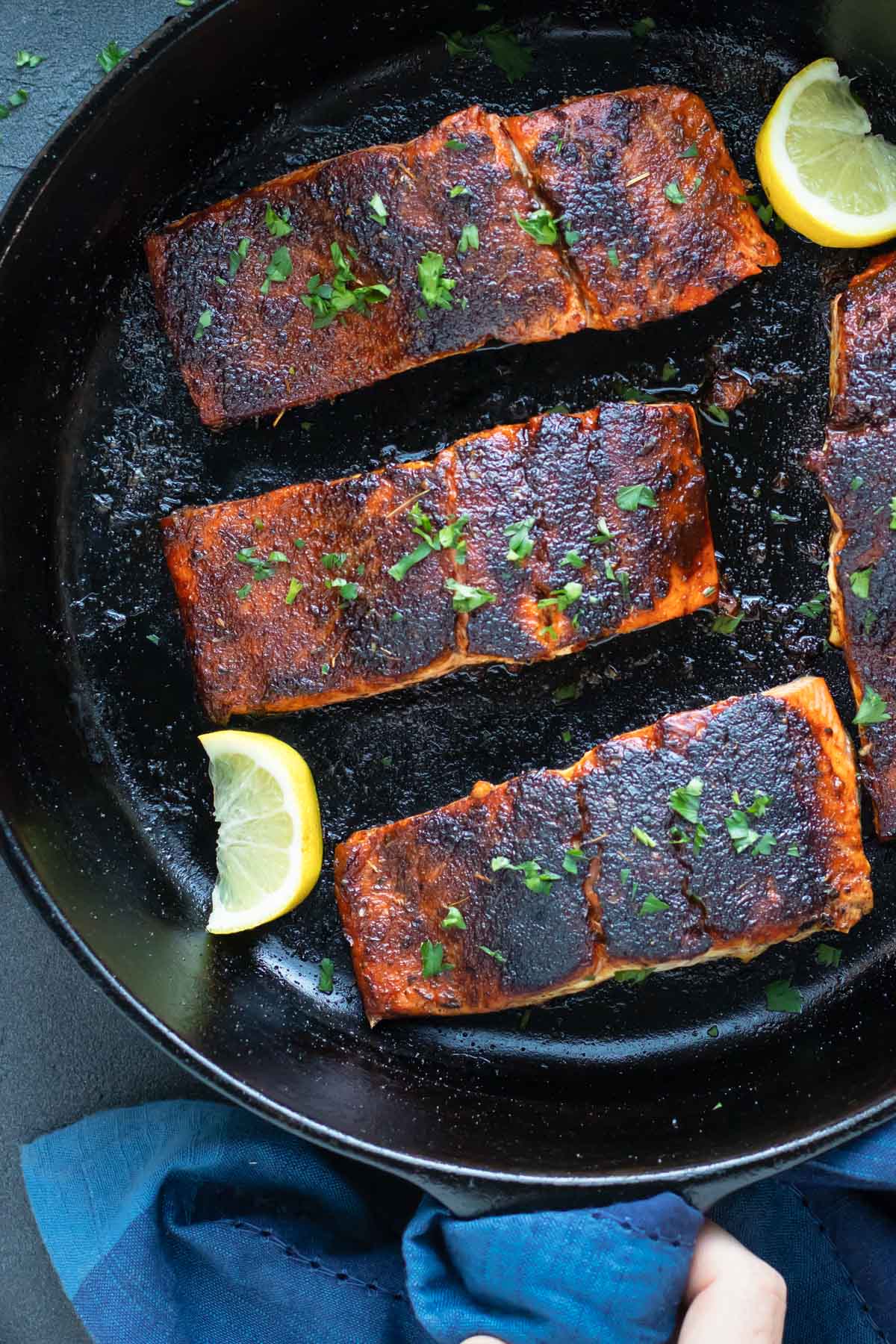Blackened Salmon (Cast-Iron Skillet) RECIPE served in a cast iron skillet with lemon.