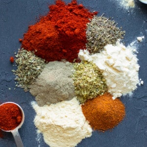 Paprika, cayenne pepper, garlic powder, oregano, thyme, salt and pepper on a board to make a blackening seasoning mix.