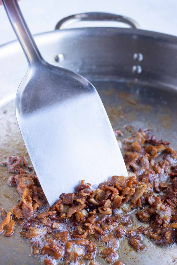 Bacon is cooked in a pan for an easy shrimp and grits.