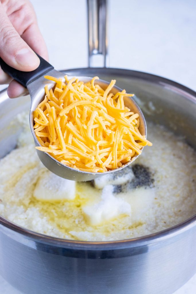 Cheese is added to the pot of grits.