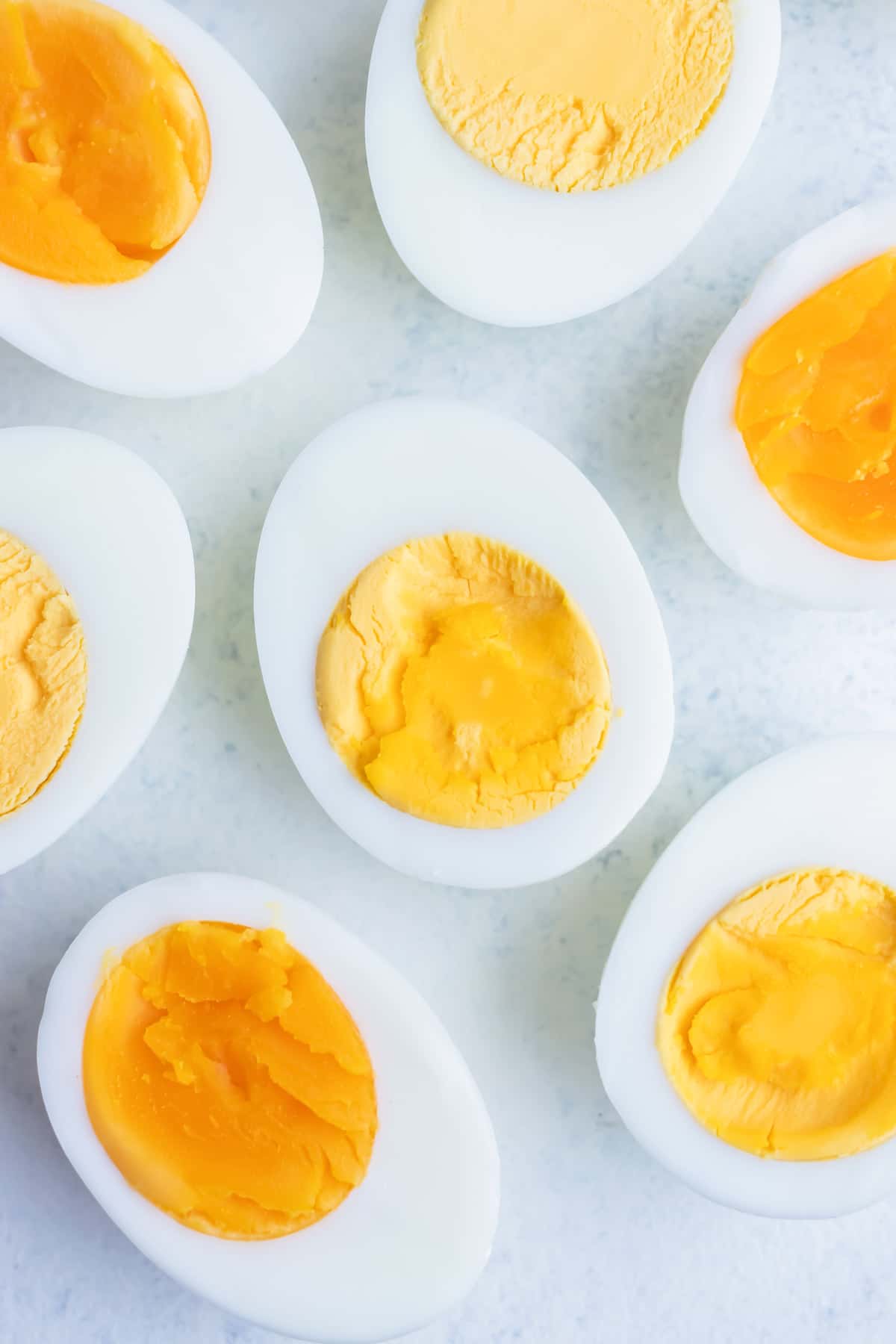 Soft-boiled and hard-boiled eggs are peeled and cut in half.