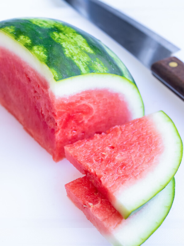Slices next to quarter of a watermelon.