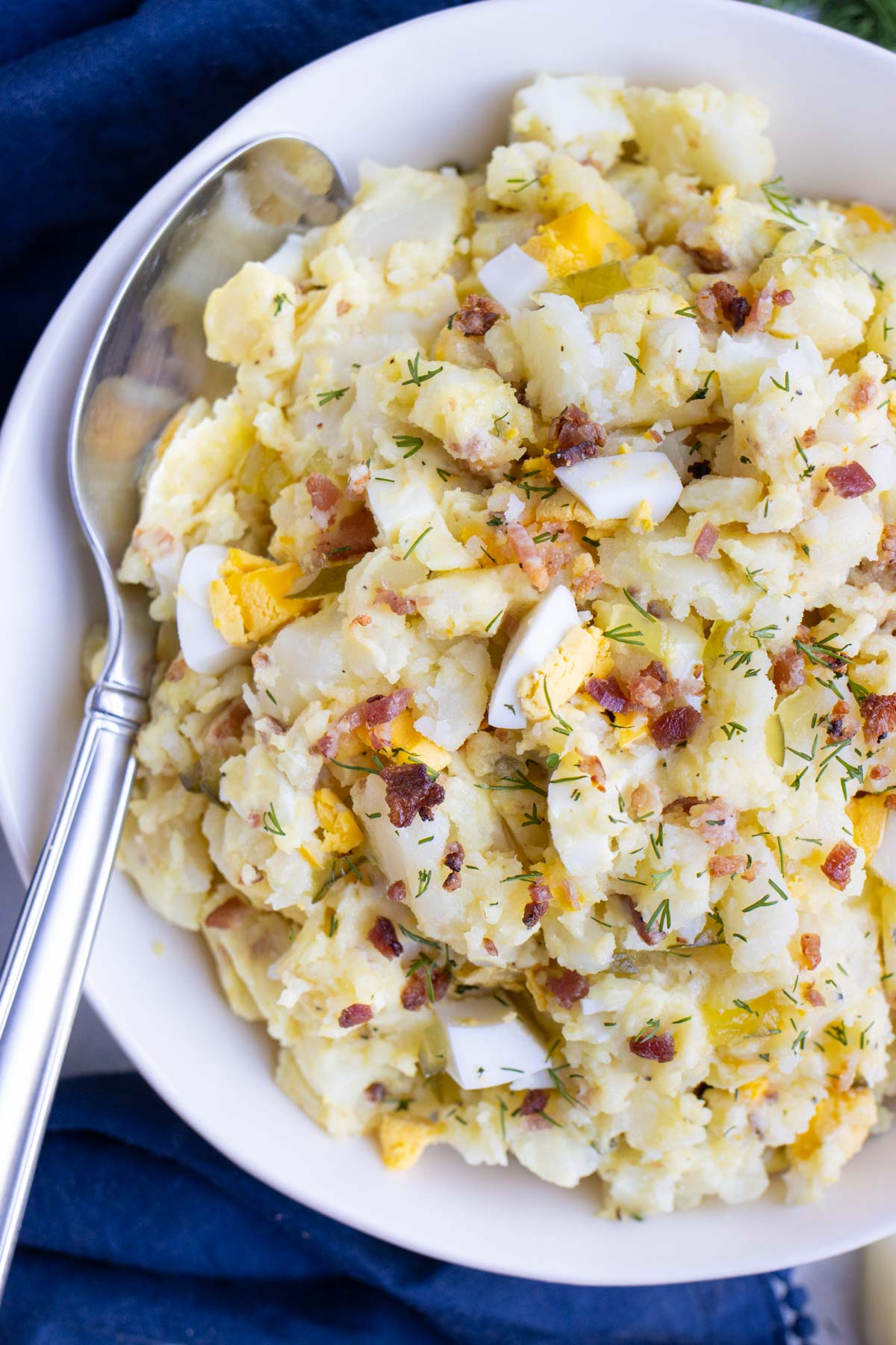 Instant Pot Potato Salad RECIPE served in a white bowl with a silver serving spoon.