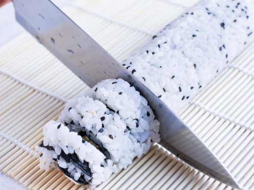 Sushi roll is cut with a wet knife.