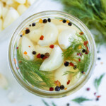 An overhead shot of pickled garlic in a jar.