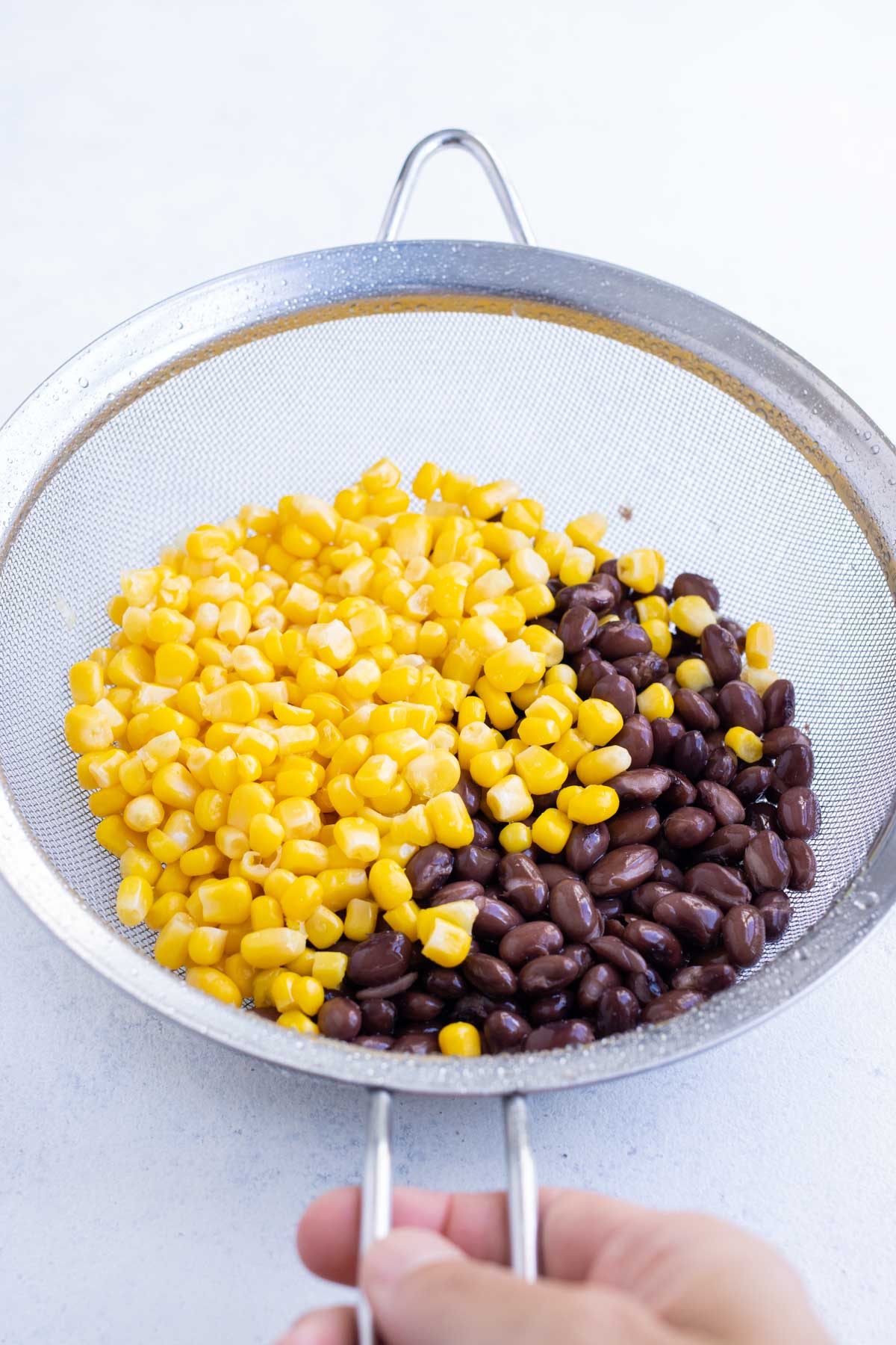 Corn and black beans are rinsed and drained.