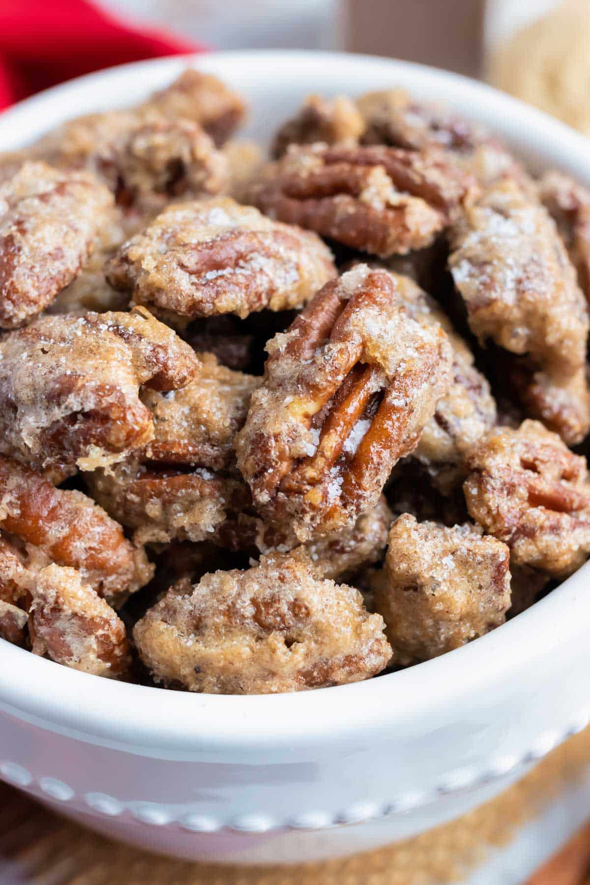 Cinnamon sugar pecans are in a white serving bowl for the holidays.