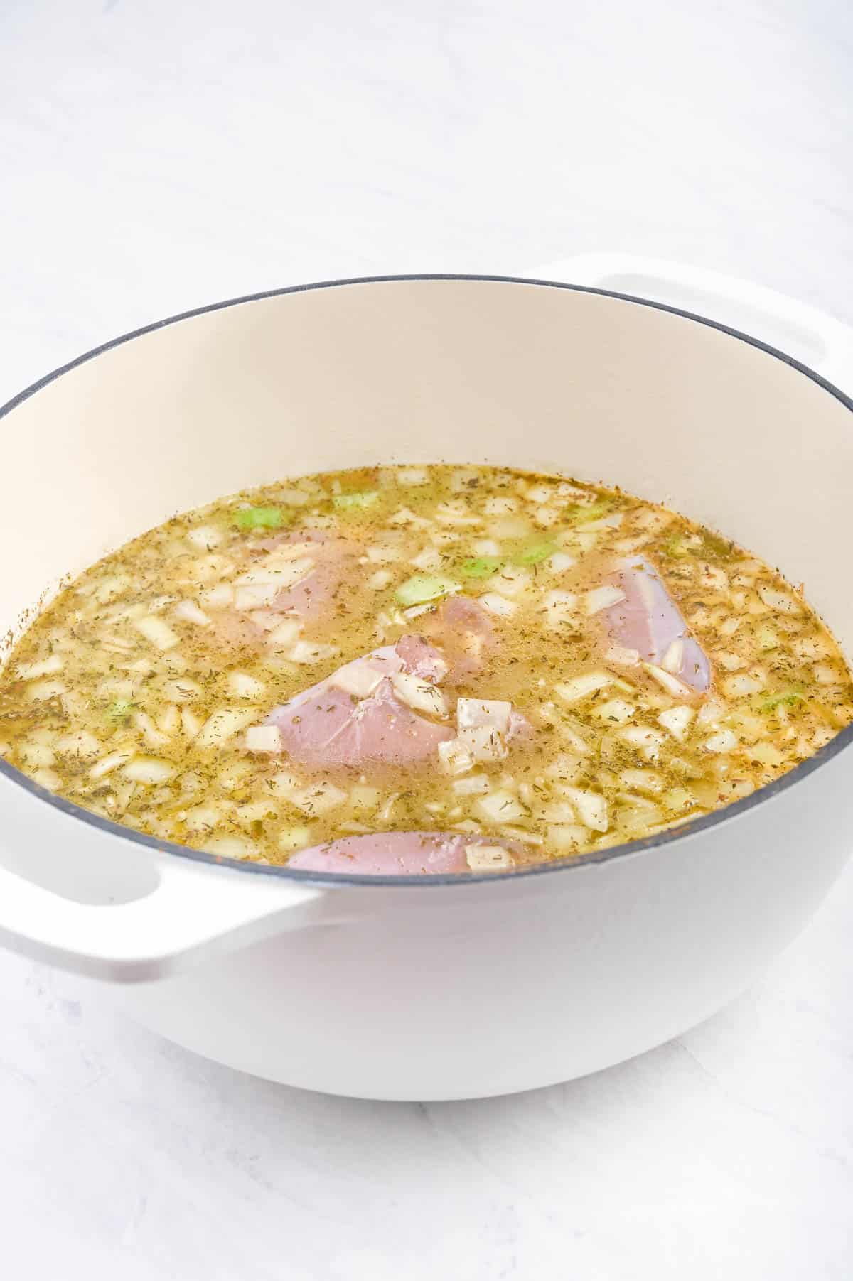 Chicken thighs are submerged in the soup.