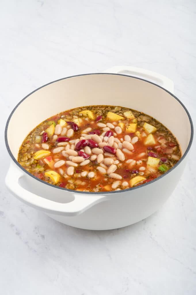 Canned beans are added to the soup mixture.