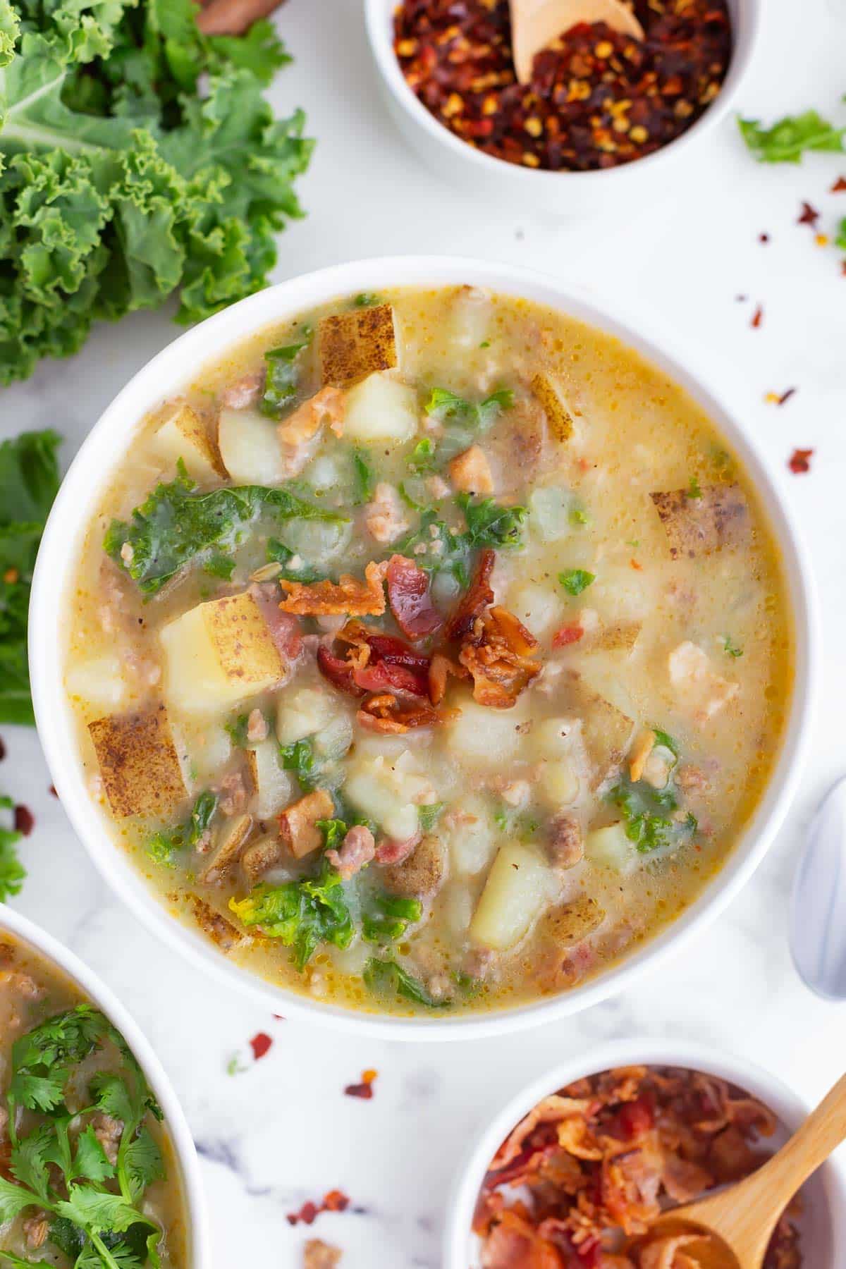 A bowl full of Olive Garden's Zuppa Toscana Soup made with a copycat recipe in a white bowl.