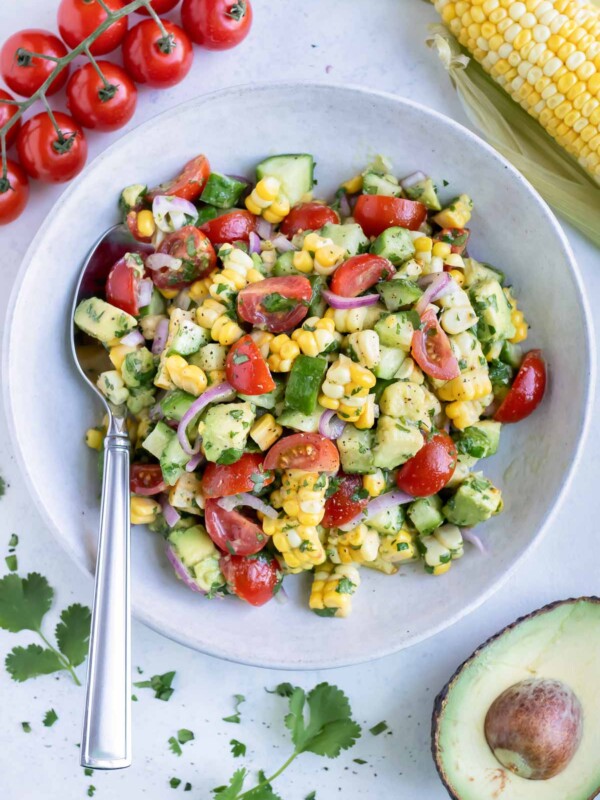 A bowl of avocado corn salad is served on the counter for a side dish.