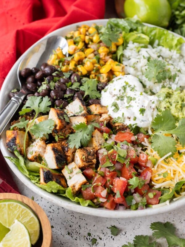 A Chipotle burrito bowl recipe is full of cilantro lime rice, chipotle chicken, guacamole, and corn salsa.