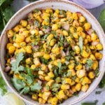 A white bowl full of a Chipotle Corn Salsa copycat recipe to be served as a dip with tortilla chips.