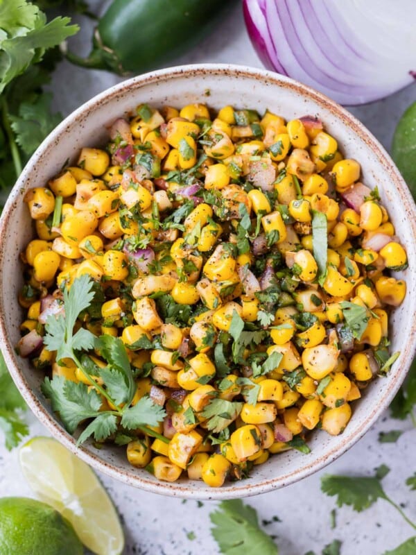 A white bowl full of a Chipotle Corn Salsa copycat recipe to be served as a dip with tortilla chips.