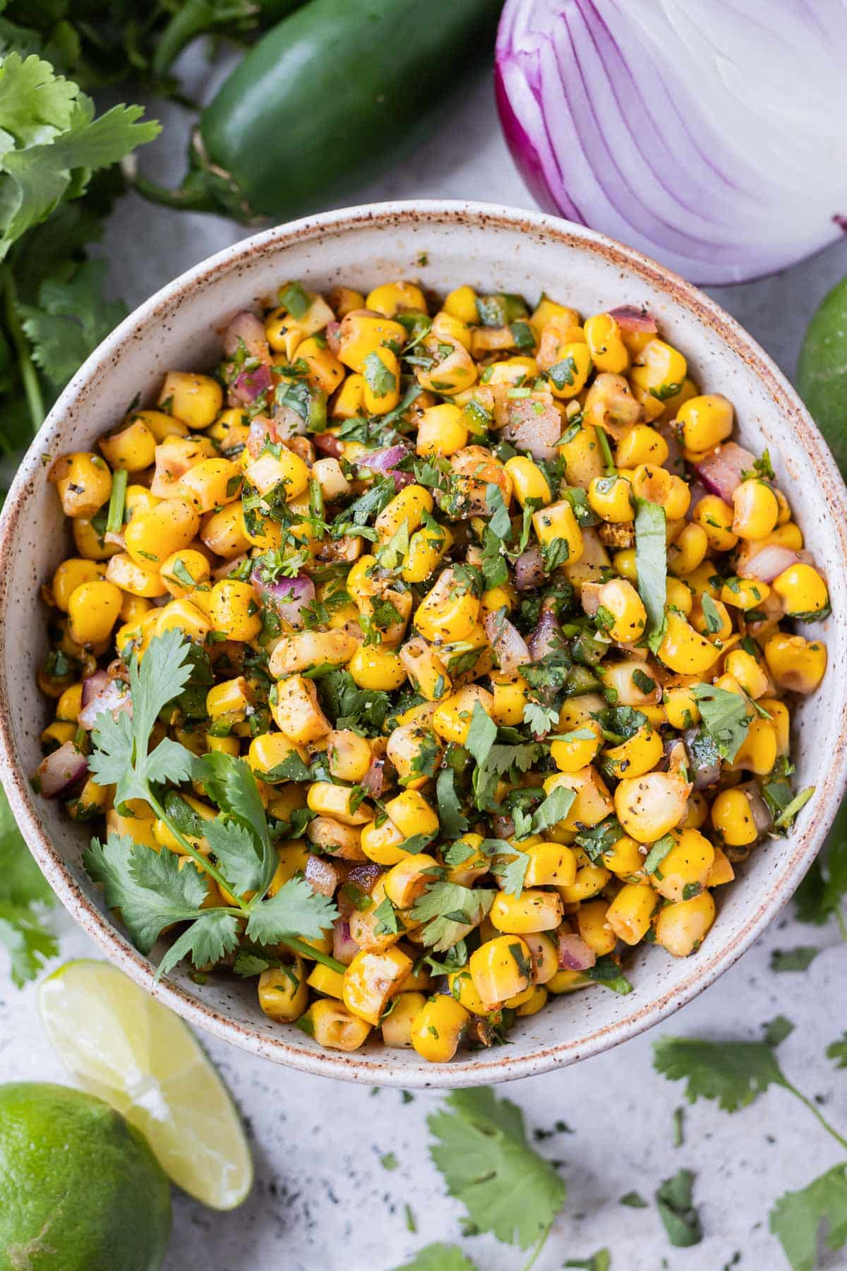 A white bowl full of a Chipotle Corn Salsa copycat recipe to be served as a dip with tortilla chips.