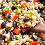 Black beans, rice, red bell peppers, and cilantro in a black skillet.