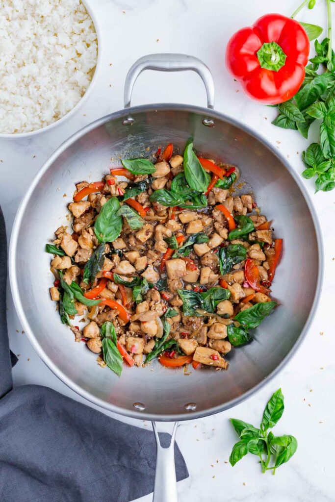 An overhead shot of Thai basil chicken in a wok.