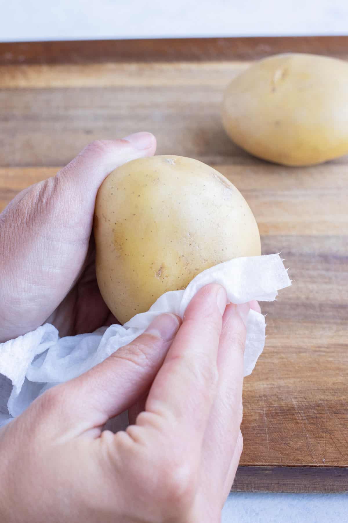 A potato being scrubbed before boiling.