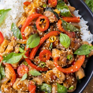 A black bowl full of an easy Thai basil chicken recipe served over basmati rice.