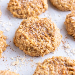 Almond butter oatmeal cookies are on a parchment paper lined baking sheet.