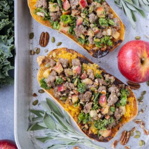 A sausage stuffed butternut squash recipe with apples, sage, and kale.