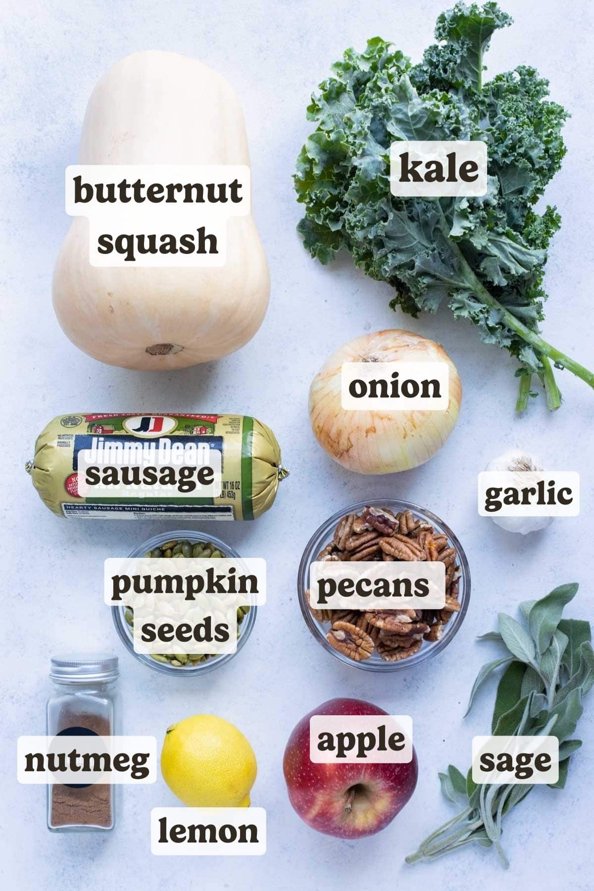 Butternut squash, onion, kale, ground sausage, pecans, garlic, apple, seeds, spices, and herbs are the ingredients for this stuffed butternut squash.