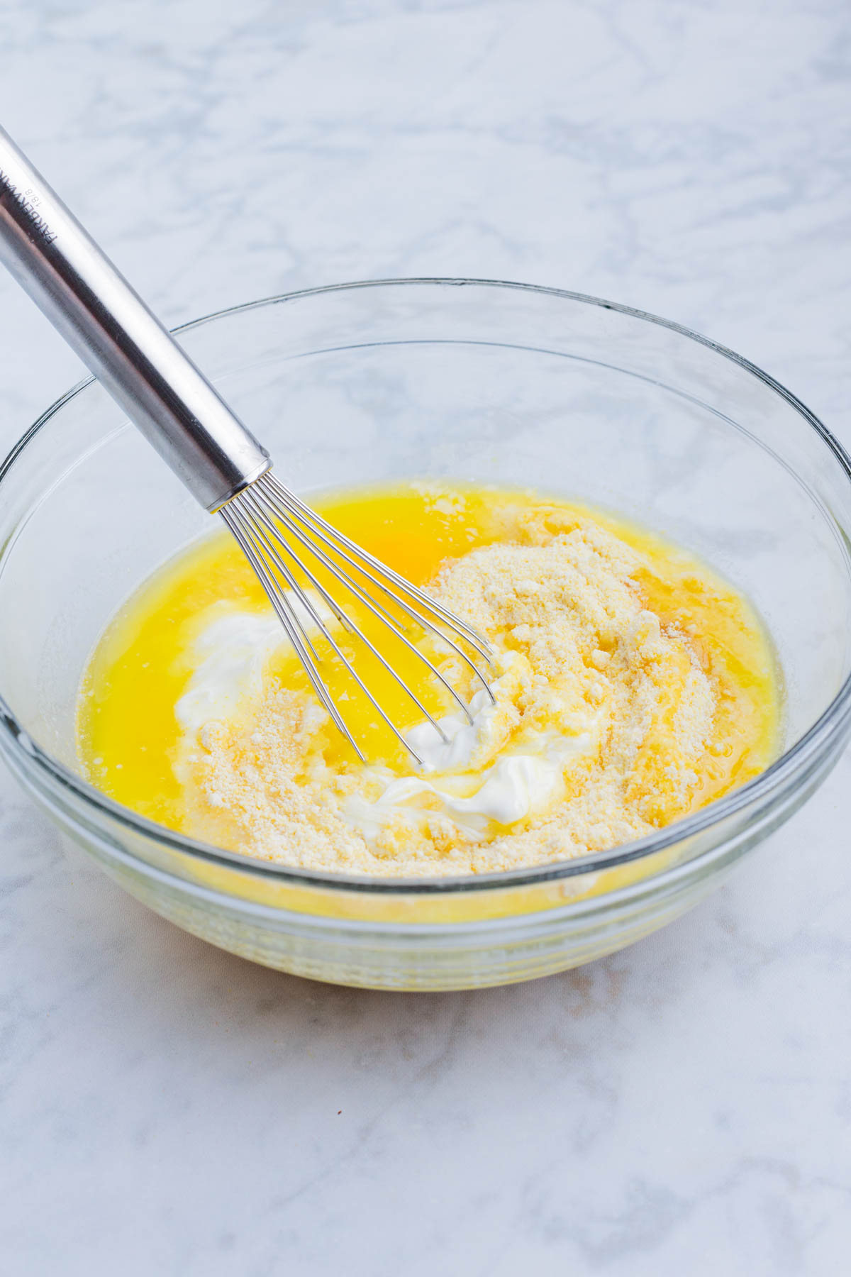 The corn souffle base is mixed in a glass bowl.