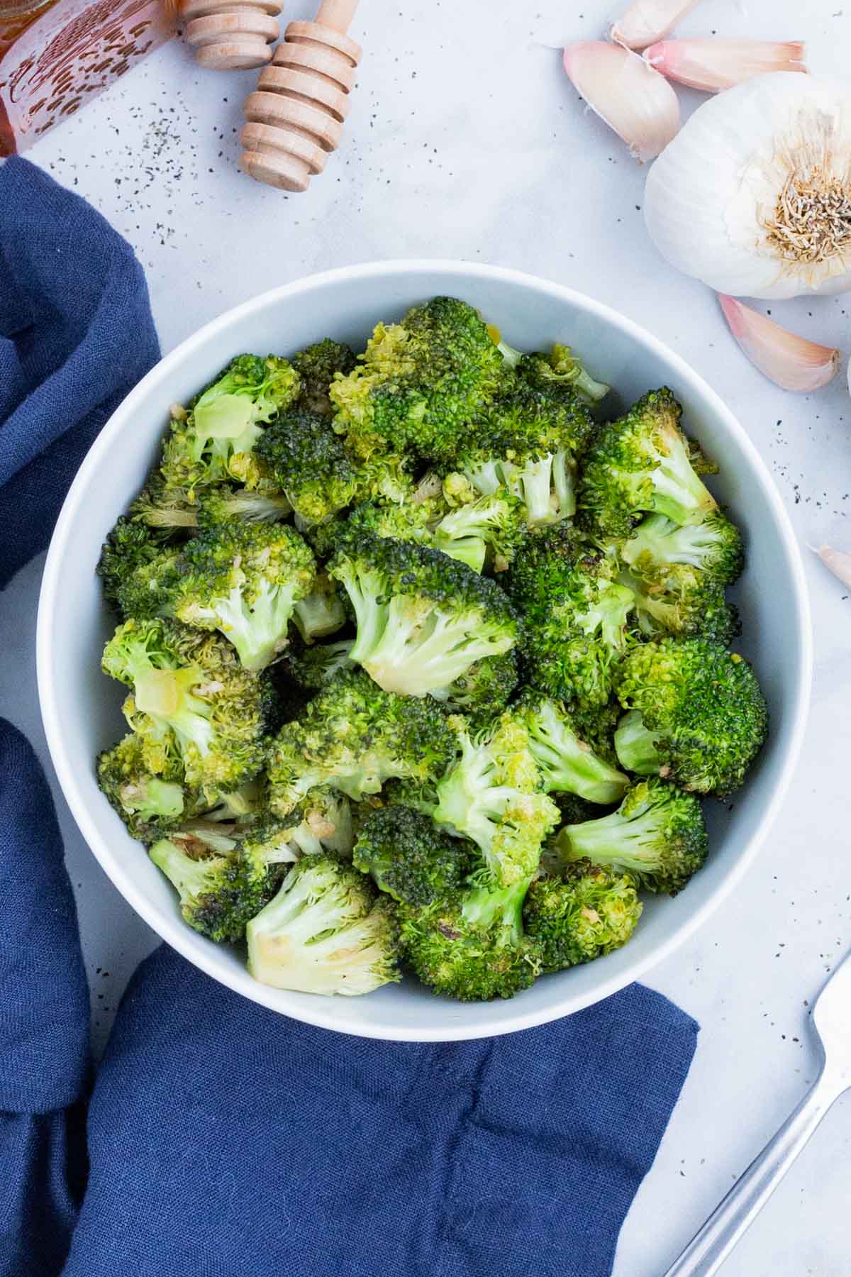 Honey-roasted broccoli is served in a white bowl.