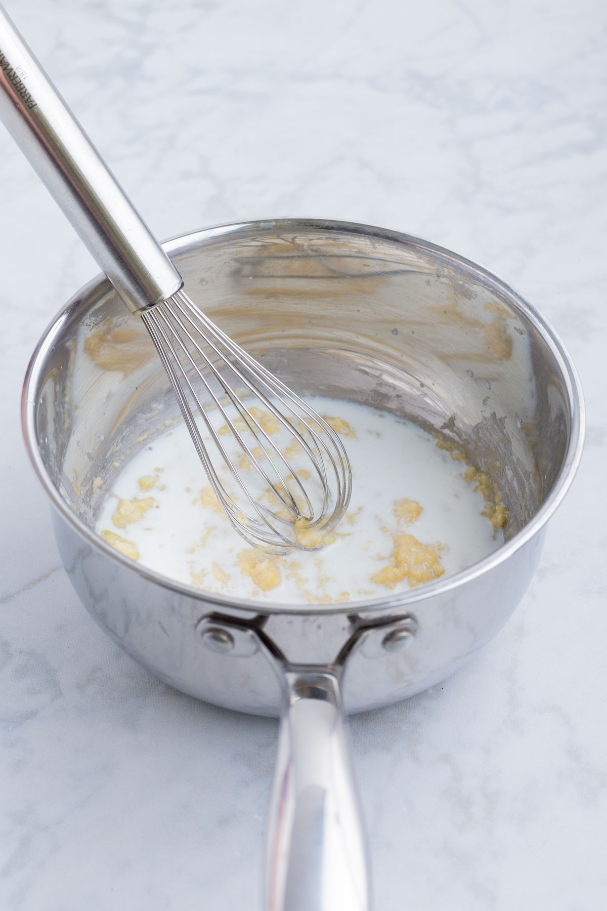 Milk is stirred into the garlic butter mixture.