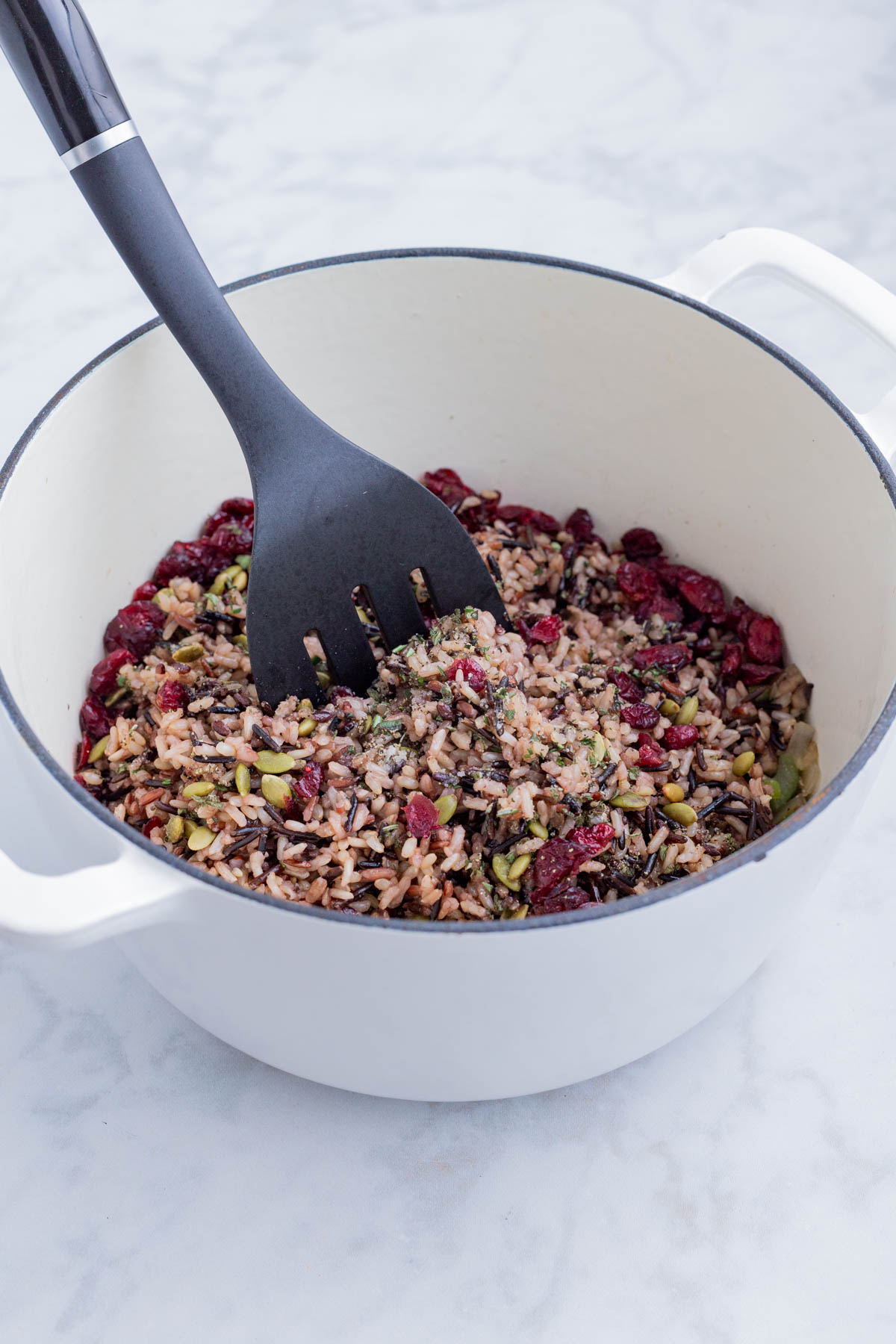 Seeds and cranberries are added to the stuffing mixture and stirred.