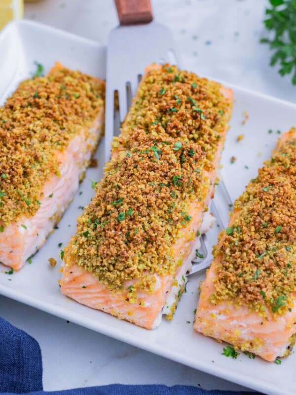 A spatula scoops a salmon filet from the tray.