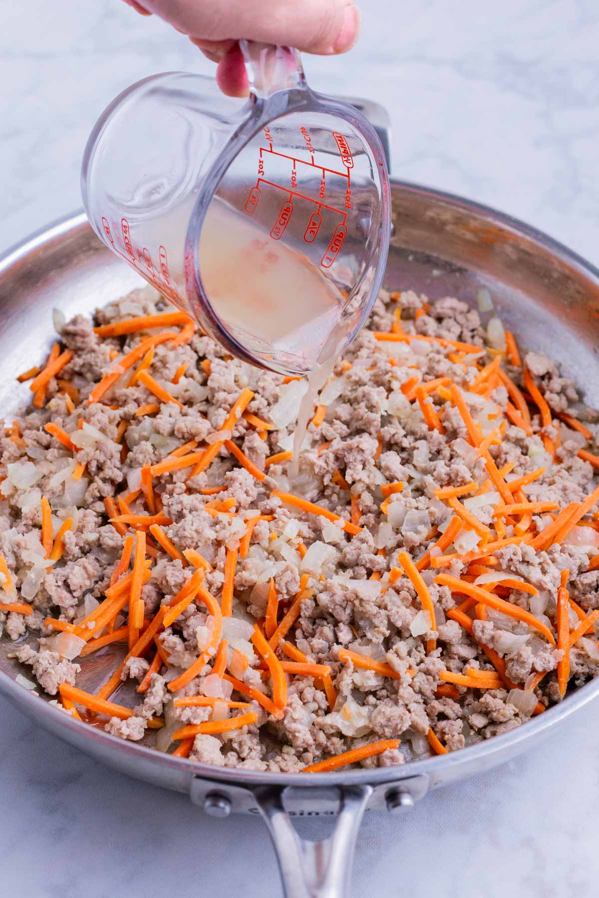 Broth is added to the skillet.