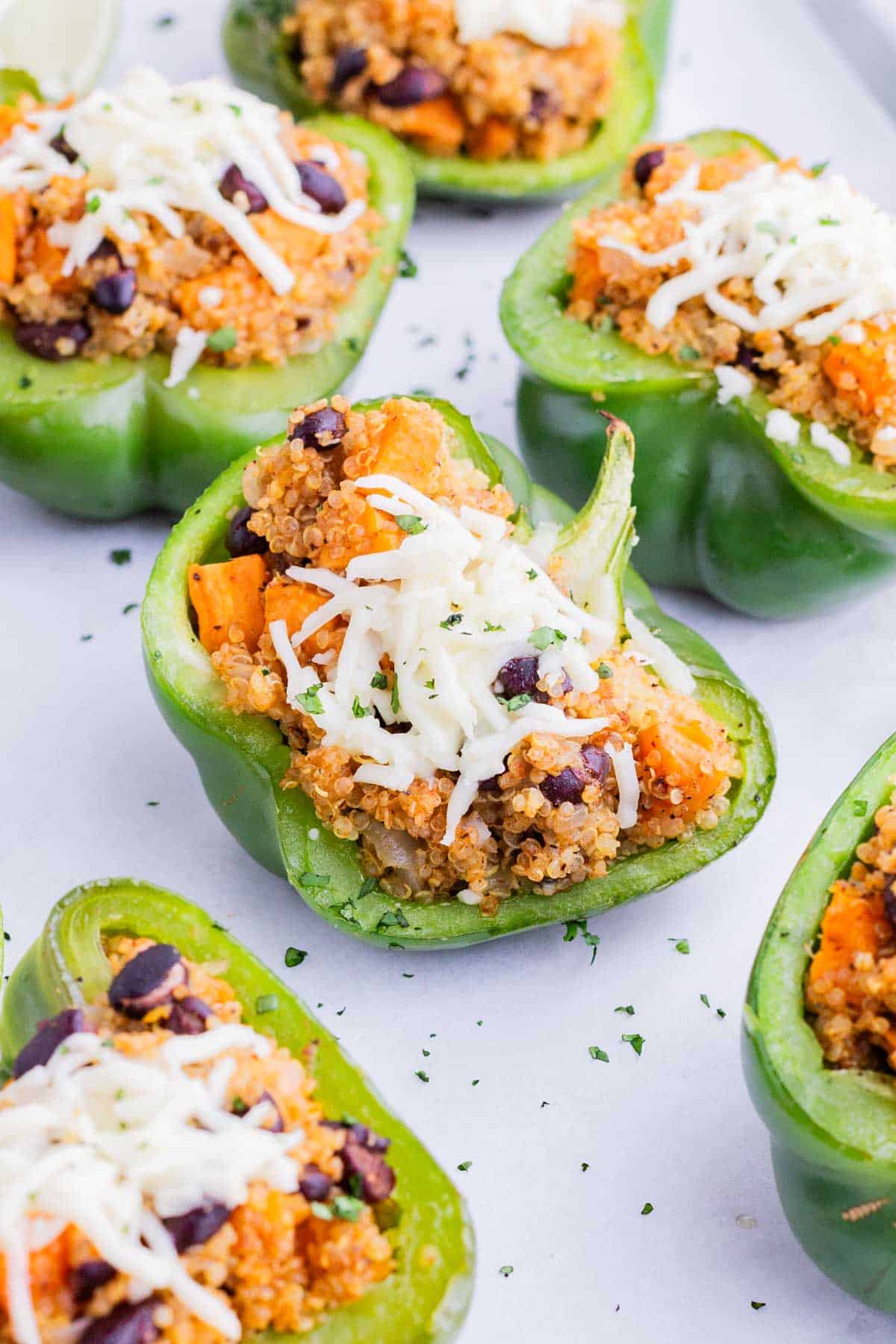 Bell peppers are stuffed with quinoa, black beans, and sweet potatoes.