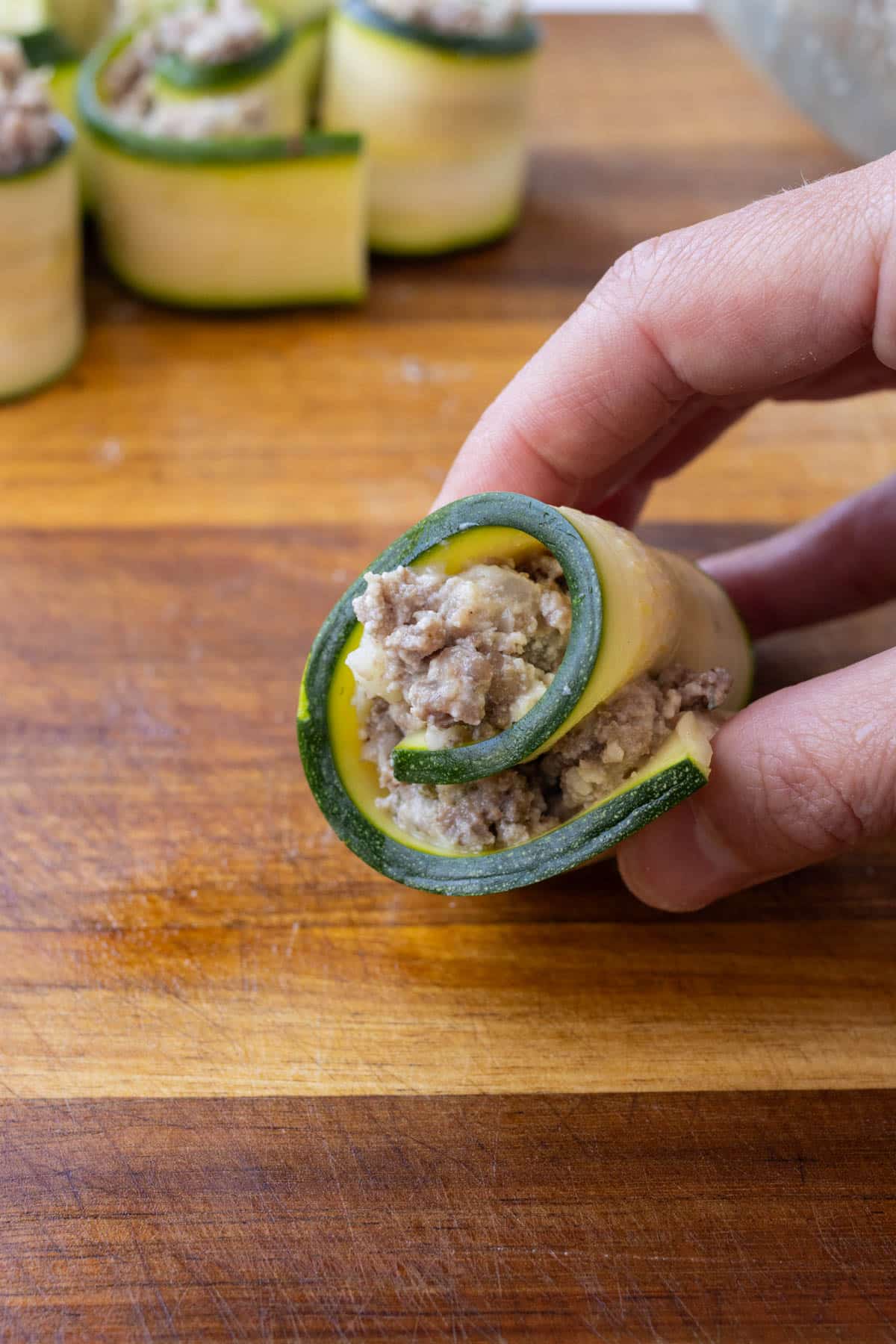 Meat filling is added to the zucchini stripped and rolled up.
