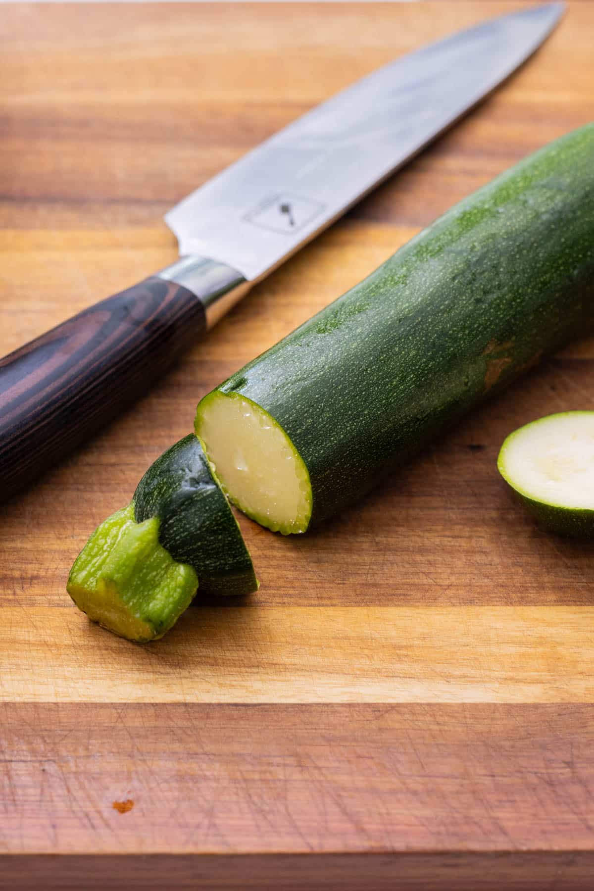 The ends are sliced off a zucchini.