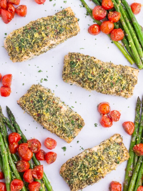 Pesto salmon is delicious when cooked with asparagus and tomatoes.