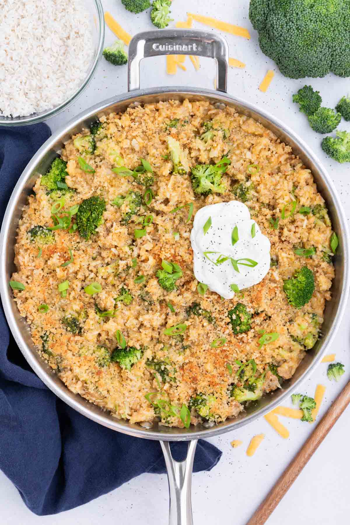 The cheesy broccoli, rice, and turkey skillet is served with a dollop of sour cream.