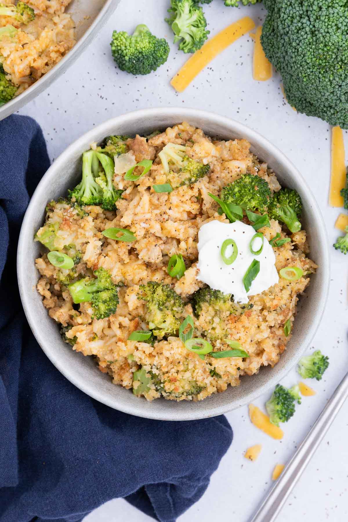 This cheesy broccoli and rice recipe is served up in a white bowl.