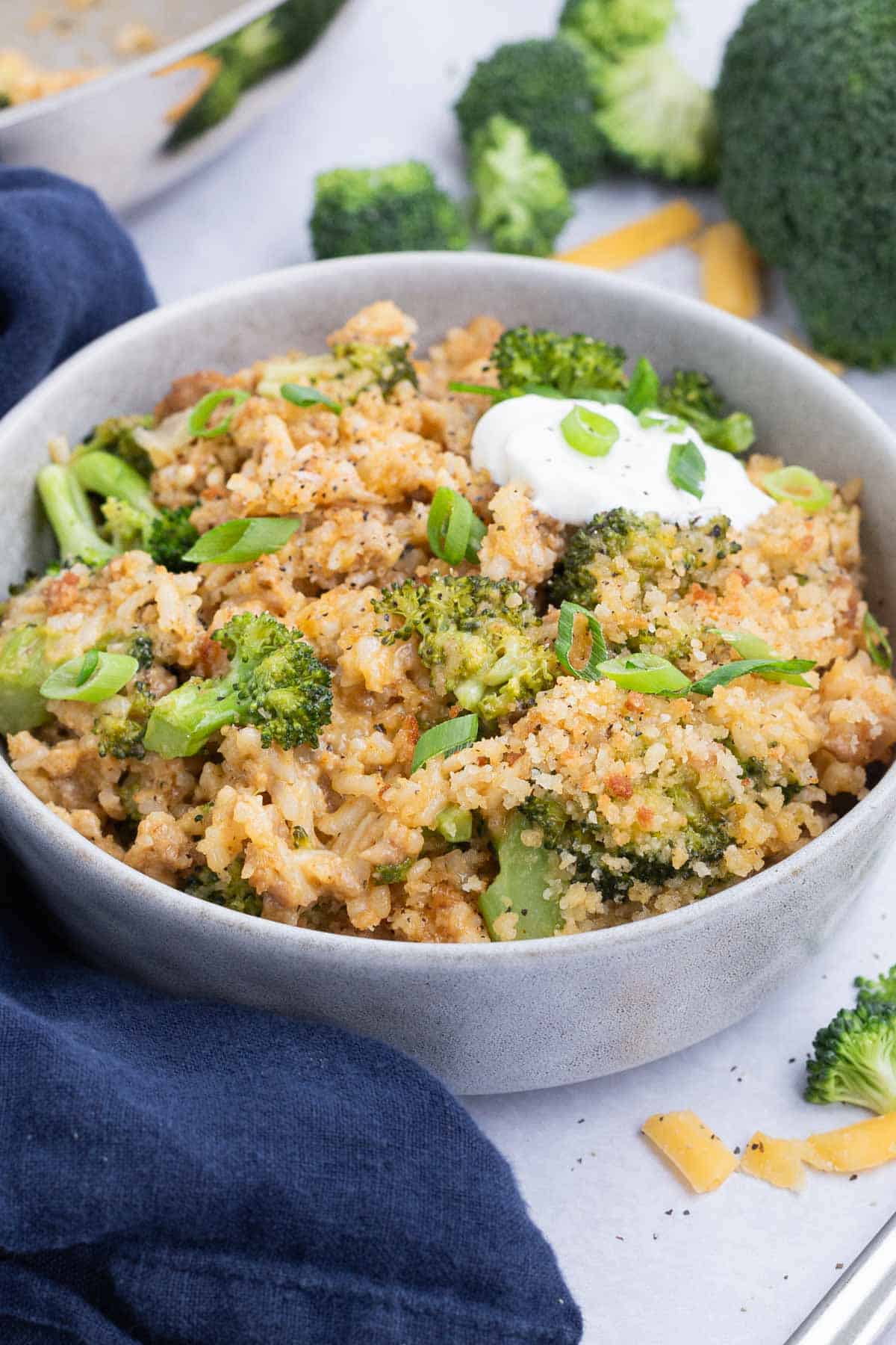 This cheesy broccoli and rice recipe is served up in a white bowl.