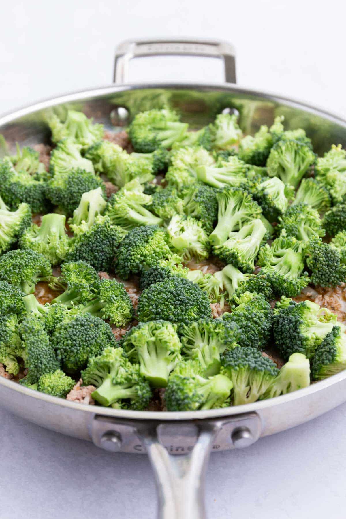 Broccoli is spread on top of the rice and turkey mixture.