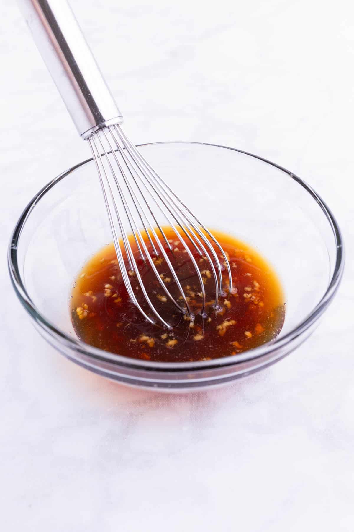 Fish sauce is whisked together in a glass bowl.