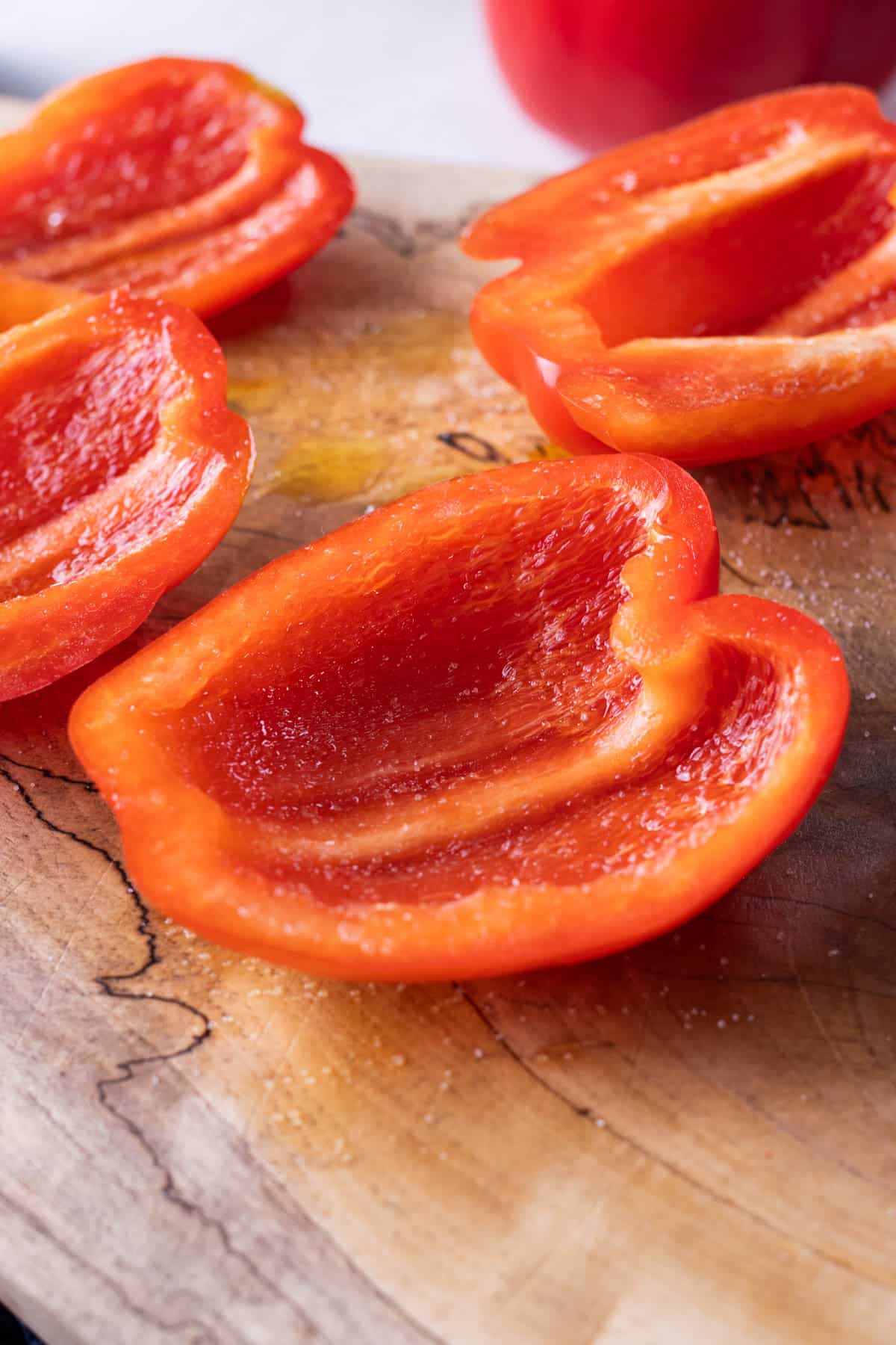 Red peppers are sliced on a cutting board.