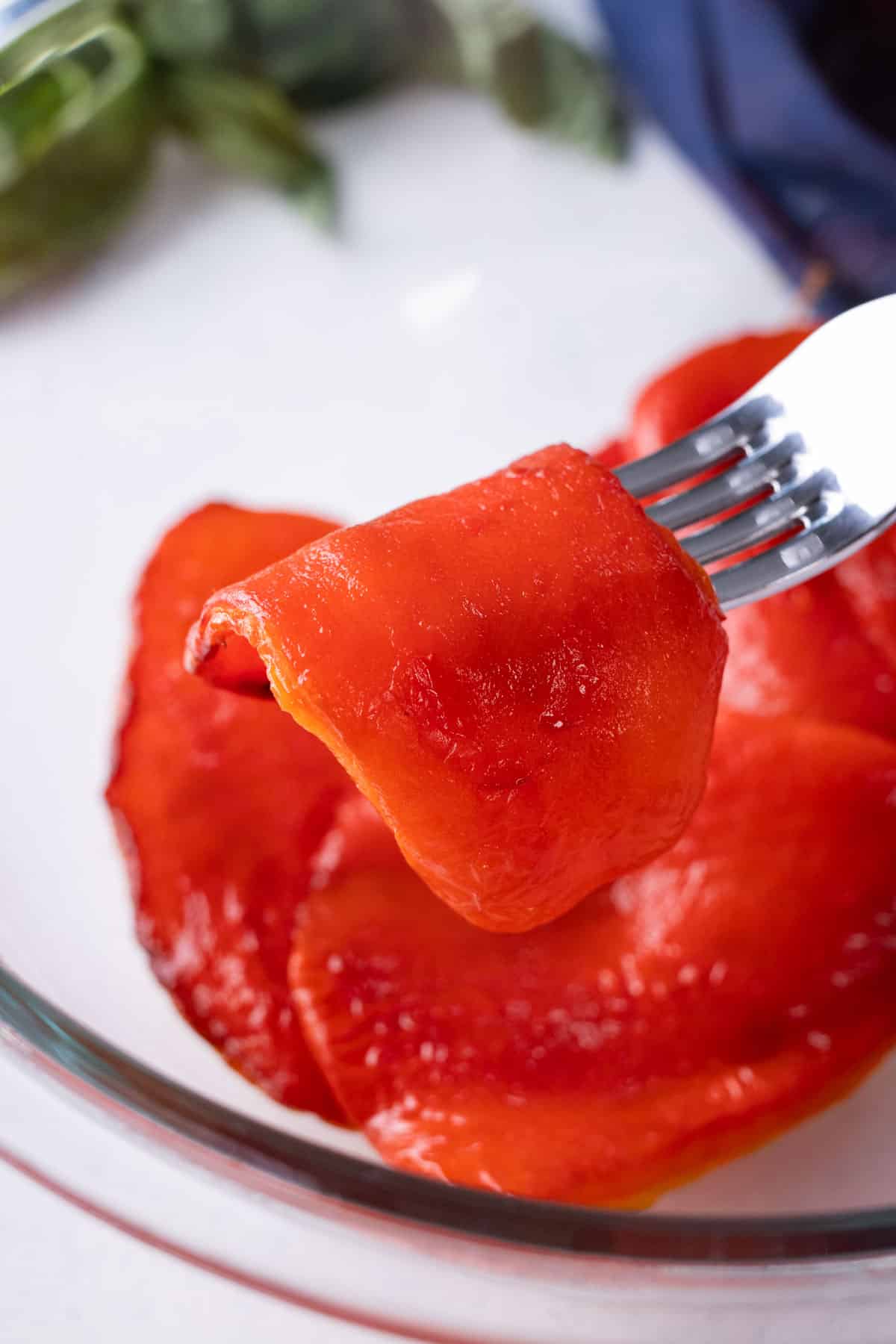 A roasted red pepper is lifted on a fork.