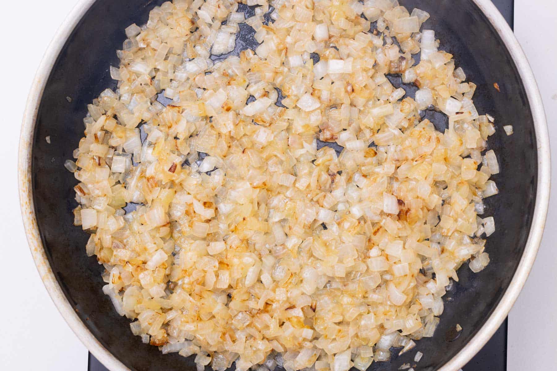 Onions are caramelized in a skillet.