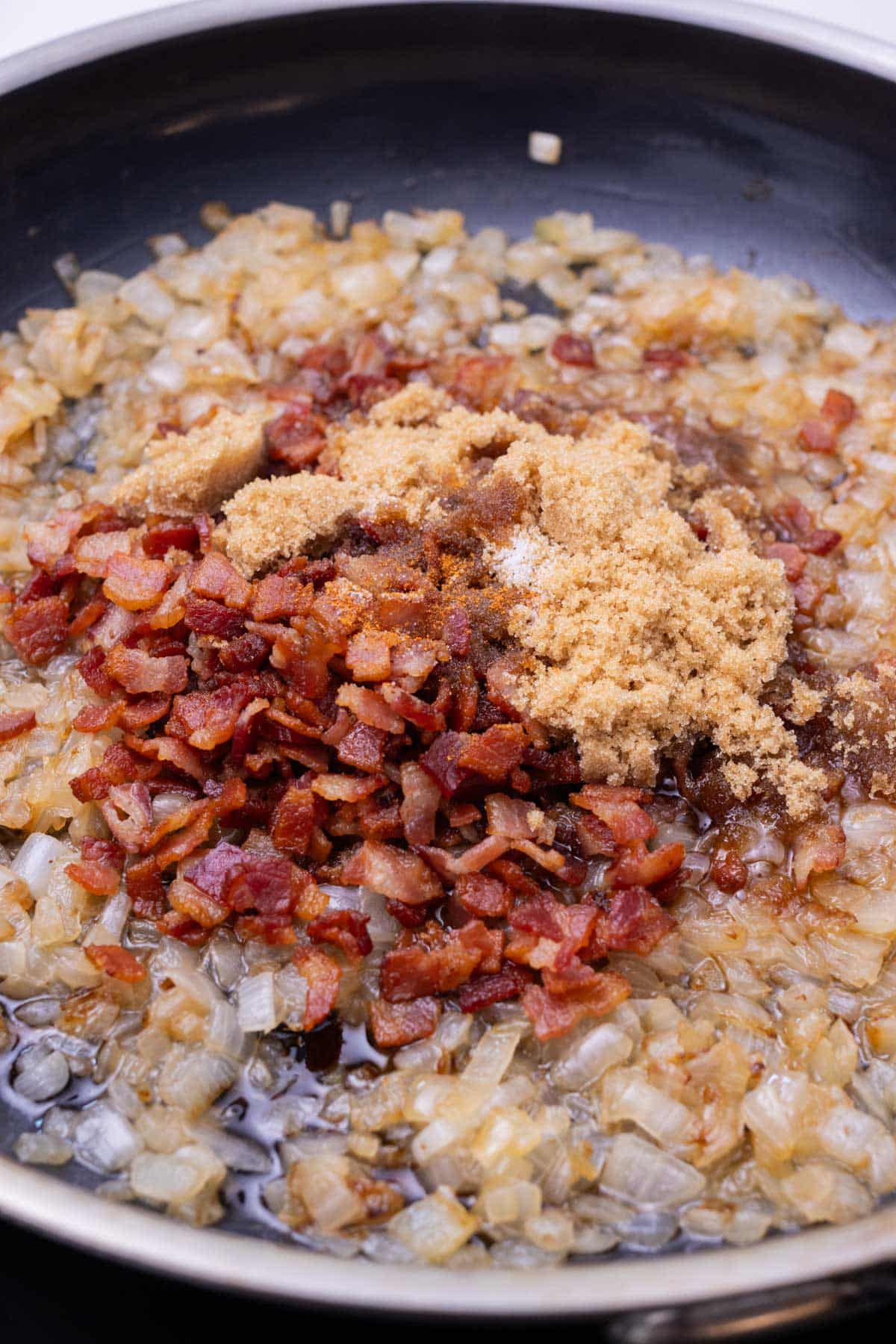 Bacon, brown sugar, and seasonings are added to the onions to make jam.