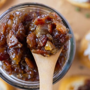 A wooden spoons scoops up some bacon jam.