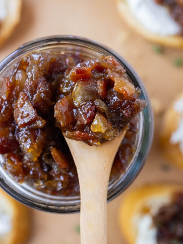 A wooden spoons scoops up some bacon jam.
